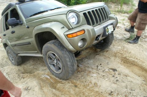 2006 Jeep Liberty - A Jeep Liberty navigates a challenging off-road terrain with steep inclines and loose dirt.