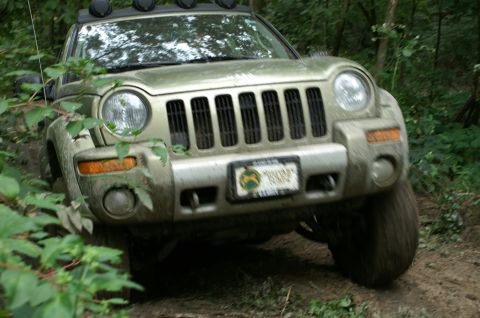 2006 Jeep Liberty - Front view of a 2006 Jeep Liberty navigating a wooded off-road path.