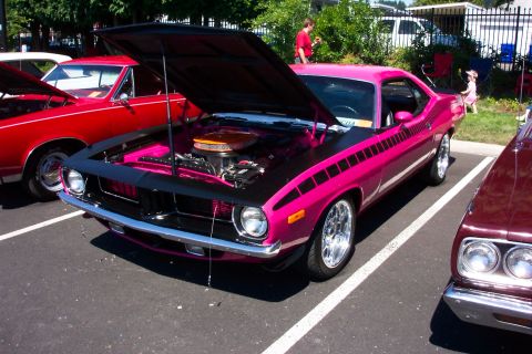1970 Chevrolet Camaro - A bright pink muscle car is displayed with its hood up at an outdoor car show.