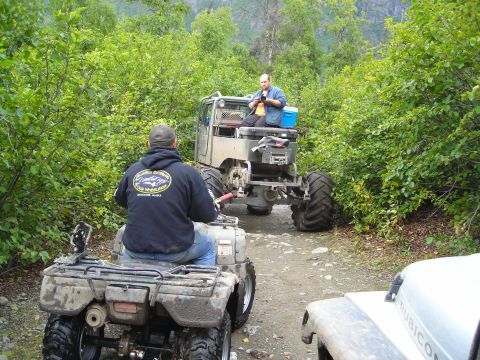 2003 Jeep TJ - Two vehicles navigate a wooded trail, with a third vehicle partially visible.