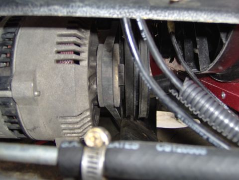 1978 Ford Bronco - Close-up view of an alternator and its associated drive belts and hoses.