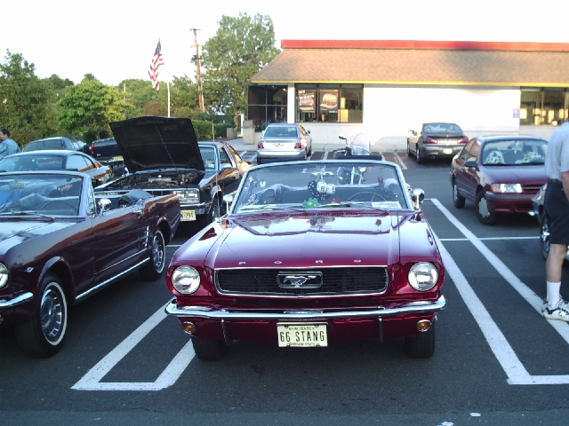 Red 1966 Mustang convertible front view with "66 STANG" license plate