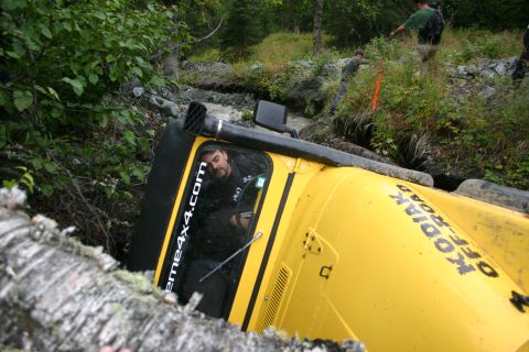 2003 Jeep TJ - A yellow Jeep TJ has overturned in a ditch, with text on its side indicating "KODIAK OFF-ROAD" and "extreme4x4.com".
