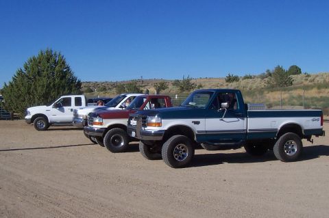 1994 Ford F-150 - Three pickup trucks, including a 1994 Ford F-150, are parked on a dirt lot.