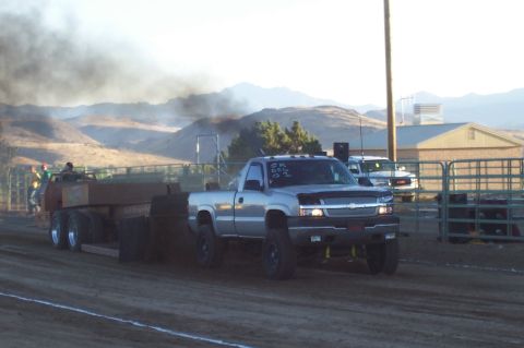 1994 Ford F-150 - A silver pickup truck competes in a pull event, emitting black smoke from its exhaust.