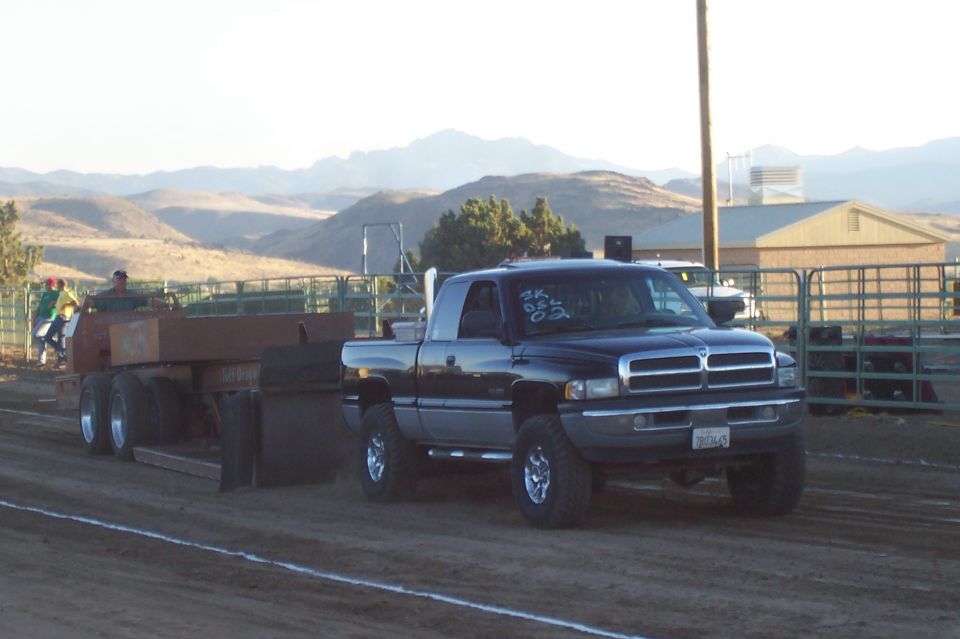 Black Dodge Ram pickup truck with a trailer, front grille visible