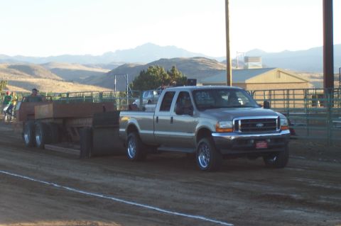 1994 Ford F-150 - A Ford F-250 Super Duty truck is seen pulling a trailer in a rural setting with mountains in the background.