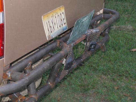 1999 Toyota Tacoma - A custom metal bumper is attached to the rear of a brown truck, a license plate and additional metalwork.