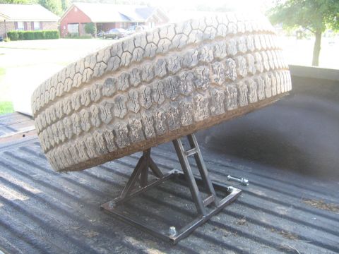 1999 Toyota Tacoma - A spare tire is secured on a custom stand within the bed of a pickup truck.