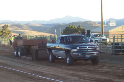 1994 Ford F-150 - A Dodge Ram pickup truck competes in a truck pull event, dragging a sled across a dirt track.