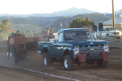 1994 Ford F-150 - A vintage blue Ford F-100 competes in a truck pull, demonstrating its towing power.
