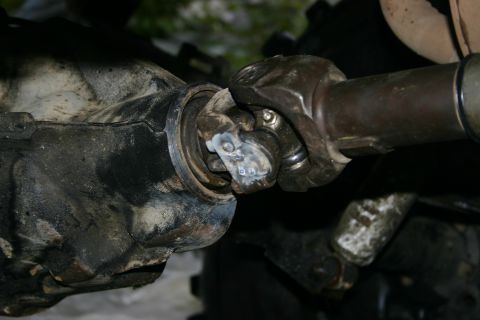 2003 Jeep TJ - This image shows a close-up view of a vehicle's driveshaft connected to the differential, focusing on the universal joint.