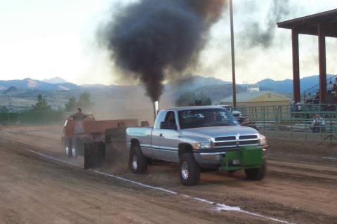 1994 Ford F-150 - A Dodge Ram pickup truck competes in a pull event, generating significant exhaust smoke.