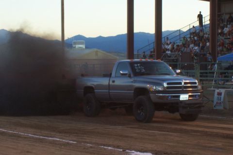 1994 Ford F-150 - A Dodge Ram pickup truck is seen during a truck pull event, emitting a large cloud of black smoke.