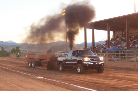 1994 Ford F-150 - GMC pickup truck competes in a tractor pull event, emitting a large cloud of black smoke.