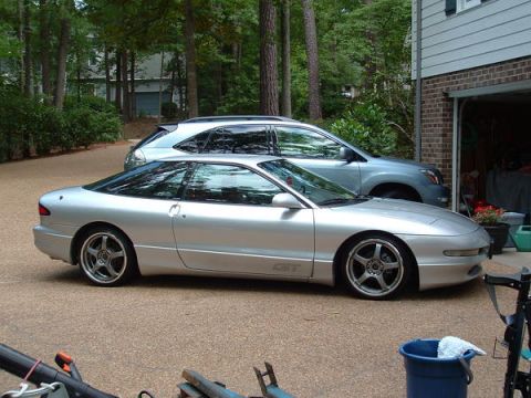1993 Ford Probe - Side view of a silver 1993 Ford Probe GT parked in a driveway with another vehicle behind it.