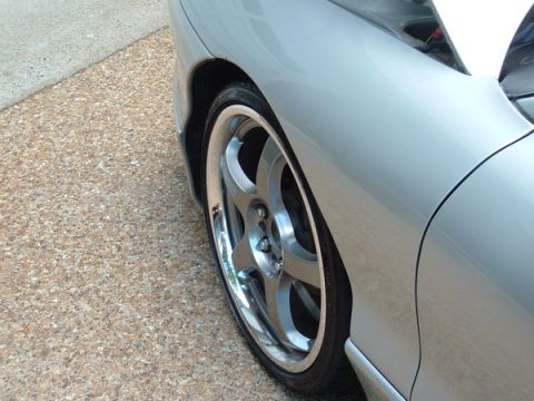 1993 Ford Probe - Close-up of a car's front wheel and fender, showing custom alloy rims.