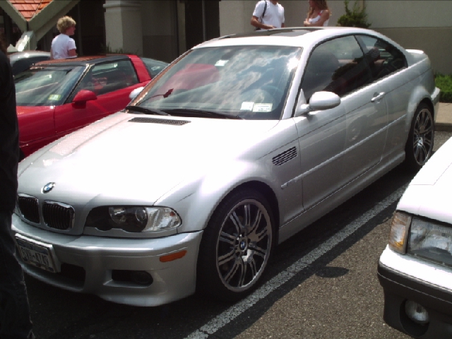 Silver BMW E46 M3 coupe parked next to a red car and a white car