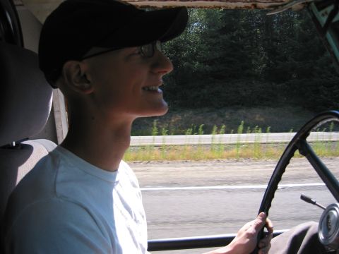 1991 Ford Explorer - A driver with a cap and glasses smiles while behind the wheel of a vehicle.