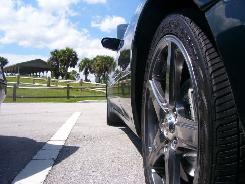 1994 Ford Probe - Car wheel and tire detail with a park scene in the background.