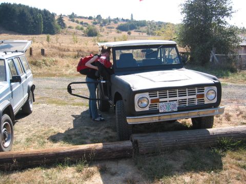1991 Ford Explorer - A person is loading items into a classic Ford Bronco. Another SUV is parked nearby.