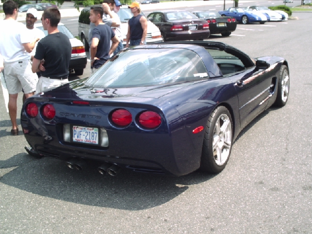 Dark blue Chevrolet Corvette C5 with quad exhaust pipes and a license plate reading PVF-2187