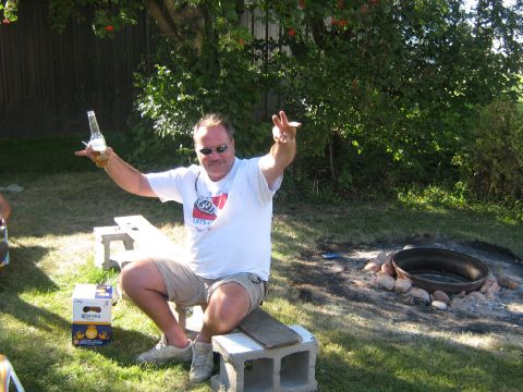 1995 Ford Bronco - A man enjoys a drink outdoors in a backyard setting with a fire pit nearby.