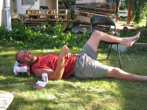 1995 Ford Bronco - Man relaxing on the grass with a beverage and cigarettes nearby.