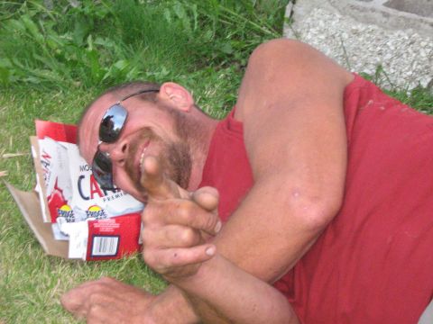 1995 Ford Bronco - A man rests on the grass next to several empty beer boxes, giving a thumbs up.