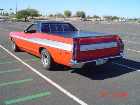 1973 Ford Ranchero - Rear view of an orange 1972 Ford Ranchero with a black vinyl top and silver trim, parked in a lot.