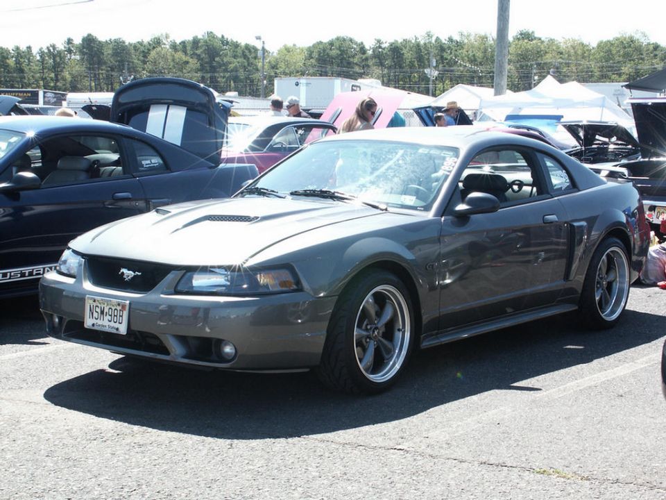 Dark gray Ford Mustang coupe with aftermarket wheels. License plate NSM-988