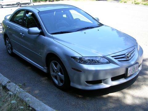 2004 Mazda 6 - Silver 2004 Mazda 6 sedan with a spoiler and aftermarket wheels is parked on the side of a road.