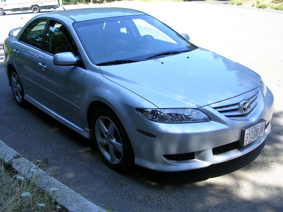 Silver 2004 Mazda 6 sedan, front 3/4 view, parked on asphalt roadside