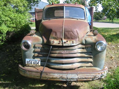 1951 Chevrolet C/K Pickup - This 1951 Chevrolet C/K Pickup shows significant rust and wear, with a wooden bed.