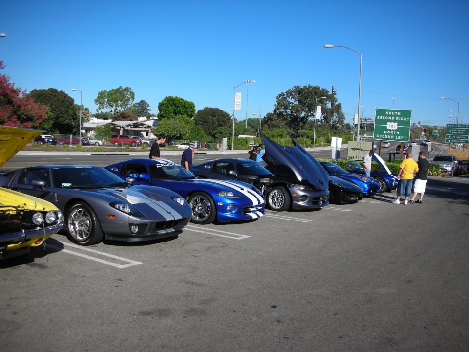 Row of supercars including a Ford GT and blue Dodge Vipers at an outdoor meet