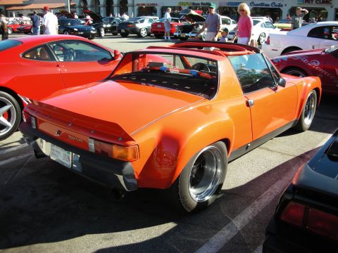 1998 Ford Crown Victoria - Rear three-quarter view of an orange Porsche 914 targa with polished deep-dish wheels parked at a car show.