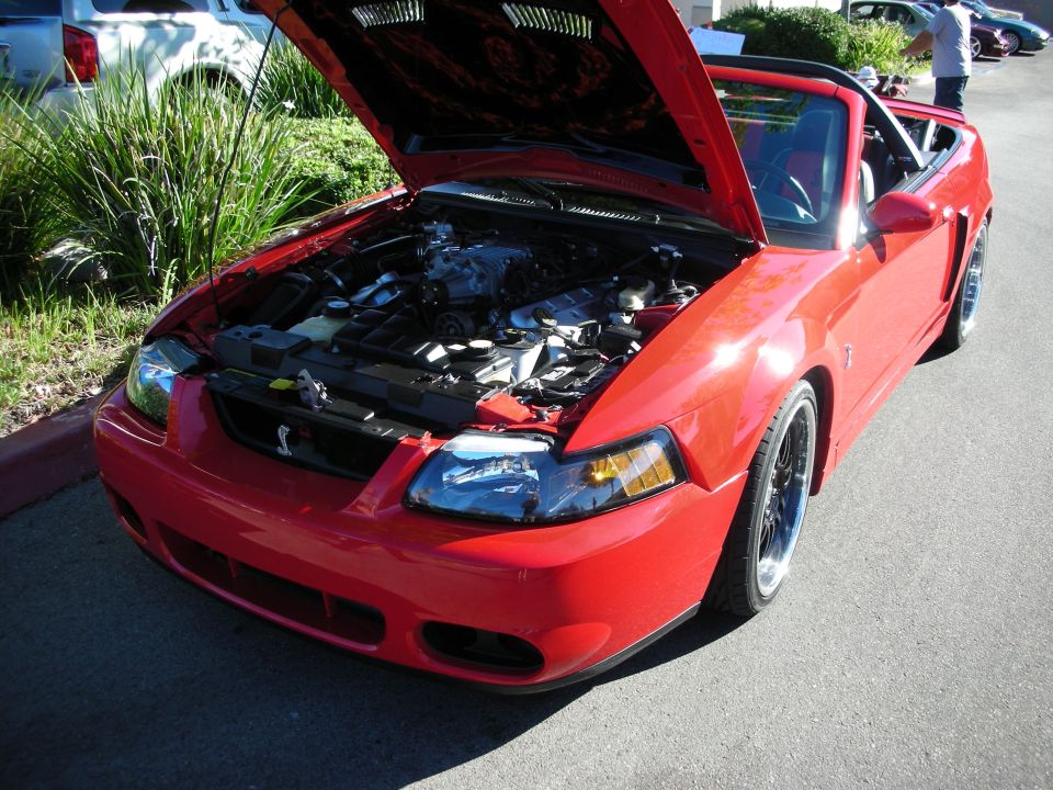 Red Mustang Cobra convertible with open hood and flame-painted underside