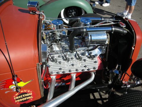 1998 Ford Crown Victoria - polished V8 hot-rod engine with dual carburetors and Grandor heads mounted in an orange roadster.