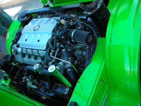 1998 Ford Crown Victoria - Cadillac Northstar 32-valve V8 engine installed in a bright green hot rod, with cone filter and green-painted accents.