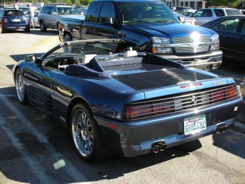 1998 Ford Crown Victoria - Rear of a dark blue Ferrari 348 convertible with louvered engine cover and a 'GR8 CHZ' plate, beside a chrome truck.