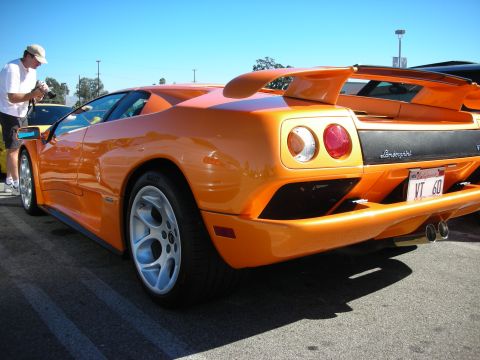 1998 Ford Crown Victoria - Rear three-quarter of an orange Lamborghini Diablo VT with round taillights, rear wing, and a California 'VT 60' plate.