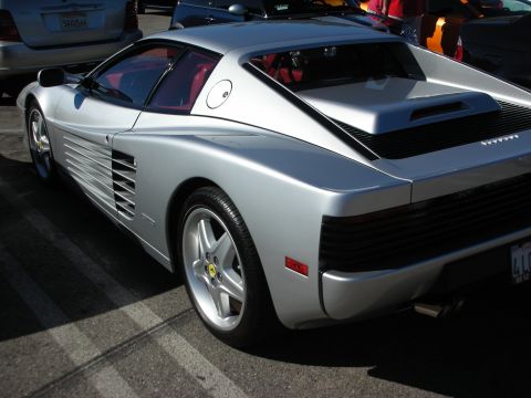 1998 Ford Crown Victoria - Silver Ferrari Testarossa shown from the rear three-quarter, showing its iconic side strakes, slatted taillight cover and five-spoke alloy…