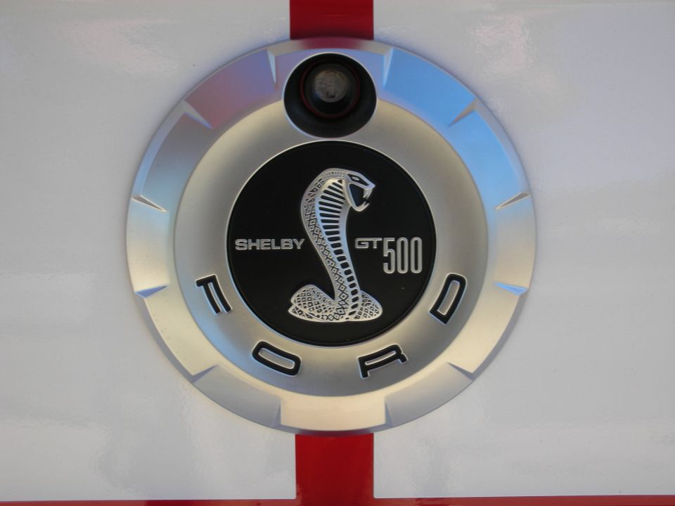 Shelby GT500 fuel-door emblem with cobra snake and Ford lettering on a white and red body