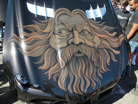 1998 Ford Crown Victoria - Black car hood featuring an elaborate airbrushed mural of a bearded old man's face with long flowing hair, viewed at a car show.