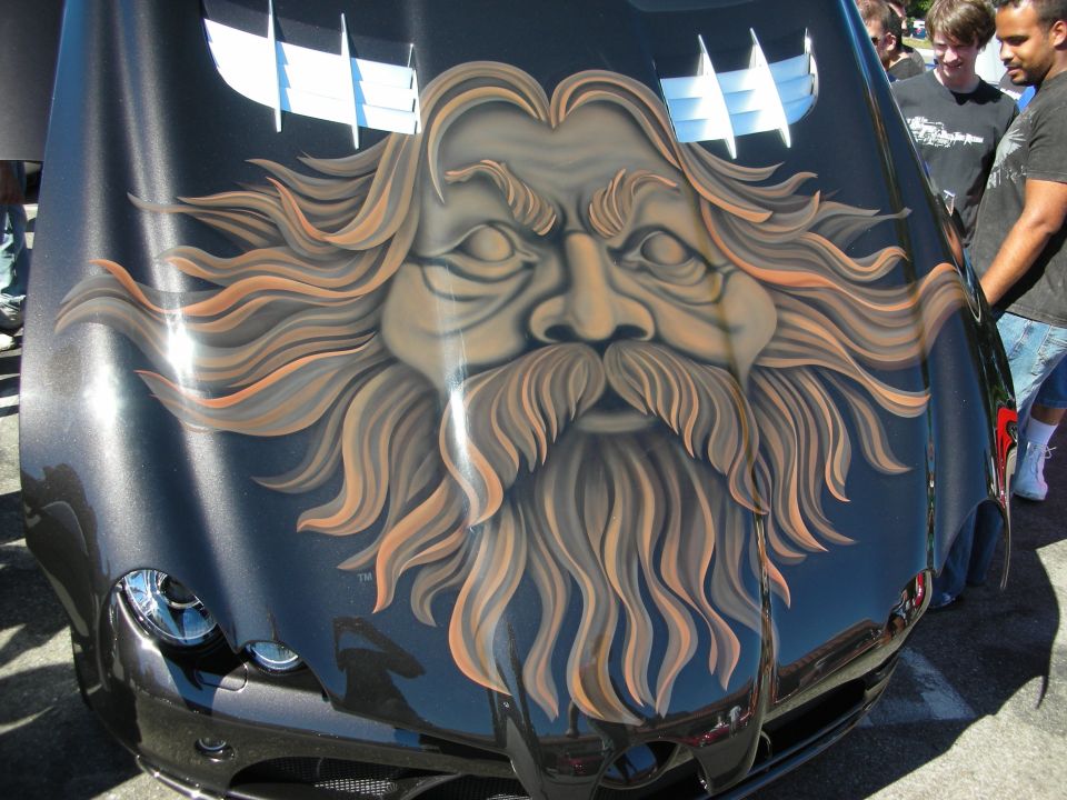 Black car hood with airbrushed mural of a bearded face surrounded by flowing hair