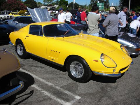 1998 Ford Crown Victoria - Yellow vintage Ferrari berlinetta on chrome wire wheels parked at an outdoor car show, surrounded by spectators and other classic cars.