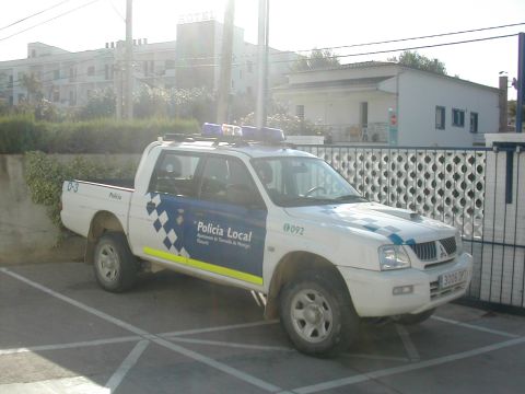 1991 Ford Crown Victoria - A white police pickup truck with 'Policia Local' markings is parked in a lot.