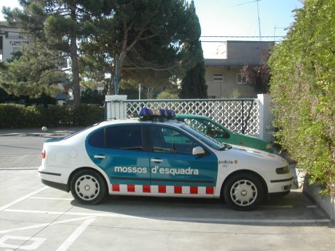 1991 Ford Crown Victoria - A police car with distinctive blue and white markings is parked in a lot next to a green vehicle.