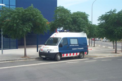 1991 Ford Crown Victoria - A police van with 'mossos d'esquadra' text is parked on the side of a road.