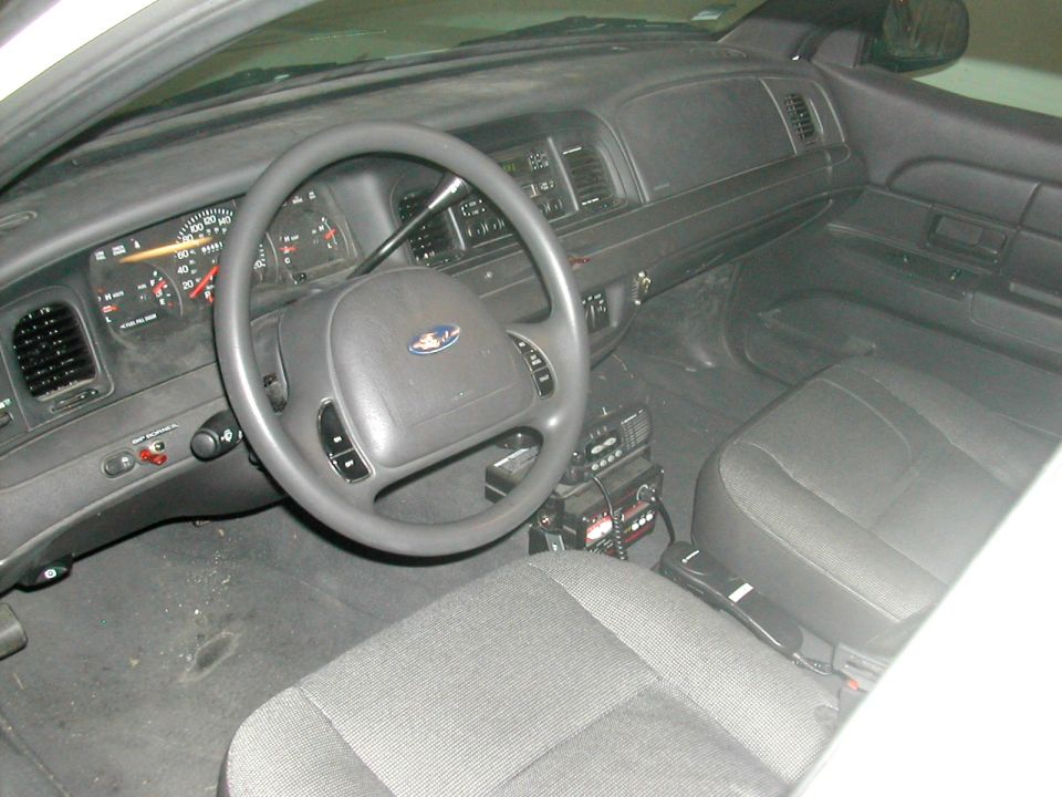 Interior of a 1991 Ford Crown Victoria police car, showing the dashboard, steering wheel, and front seats